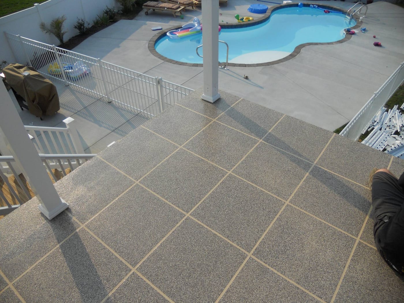 Polyaspartic flooring system on a pool-side deck with a decorative tile pattern