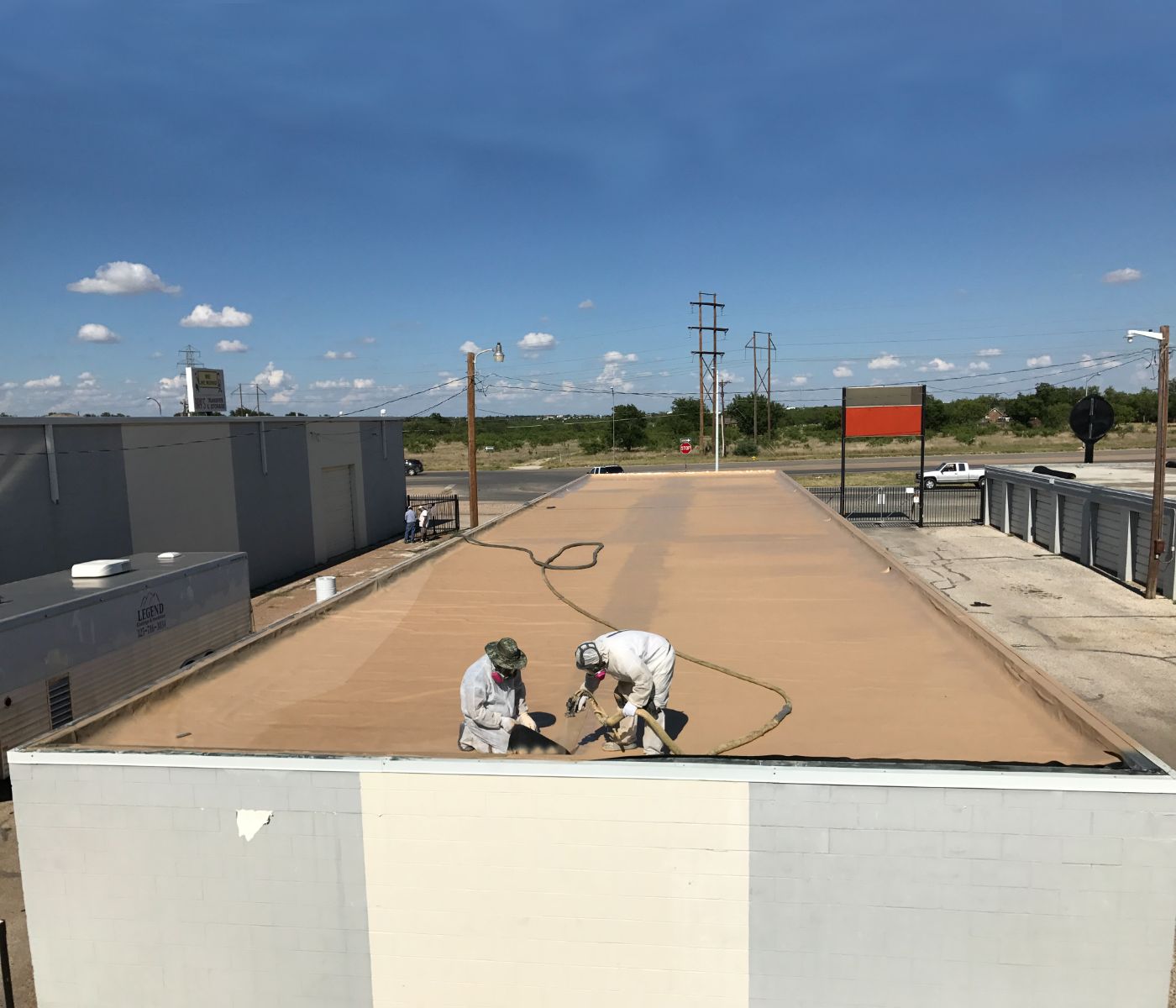 two workers rehabilitating a roof with polyurea
