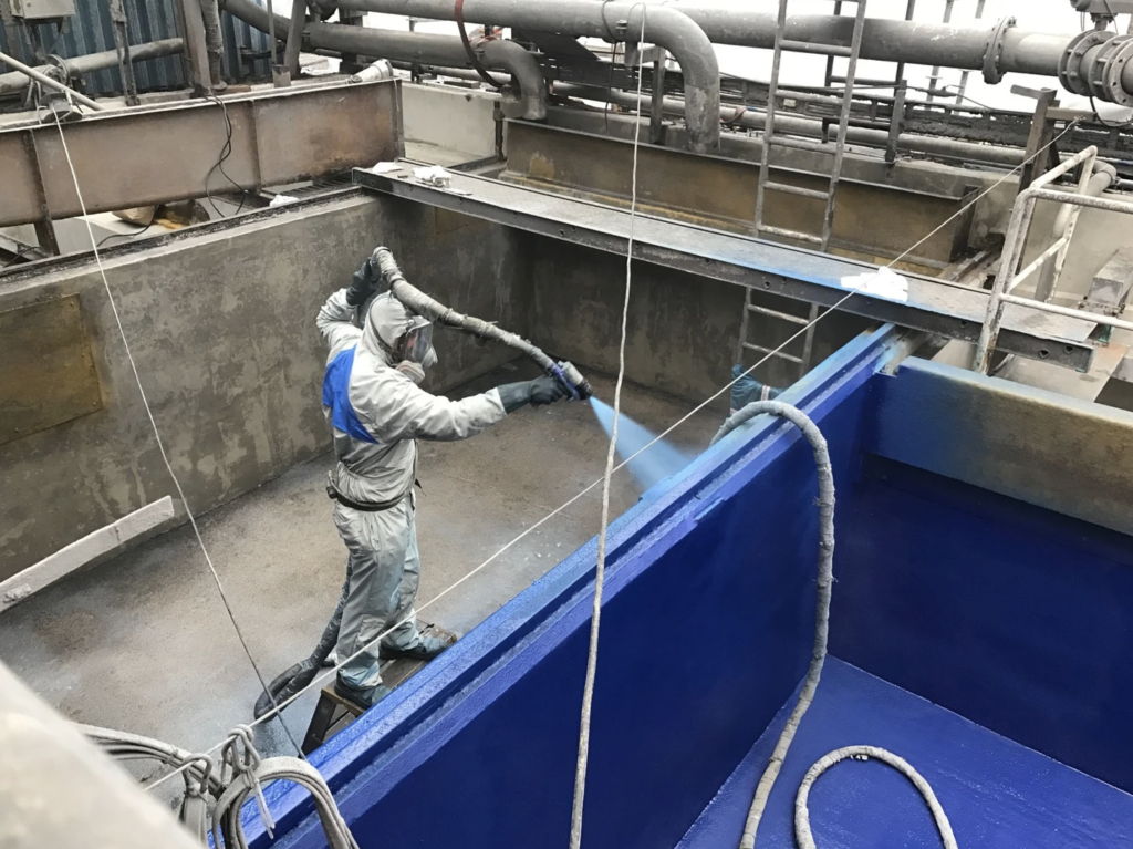 technician applying polyurea to concrete